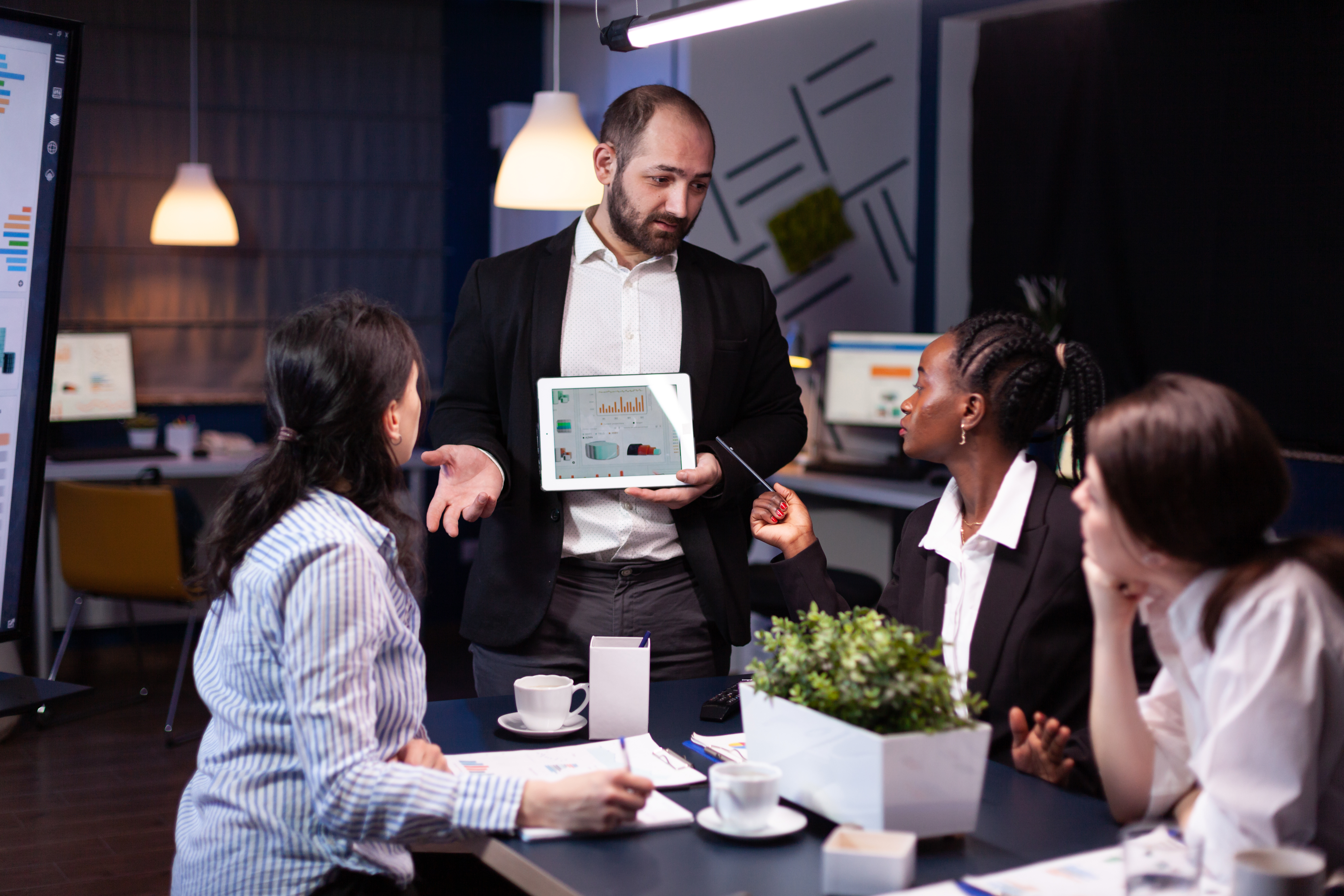 Overworked businessman showing financial graphs presentation using tablet
